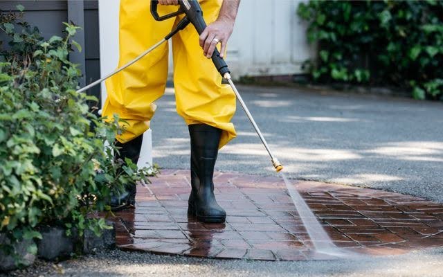 man cleaning floor with high pressure cleaner